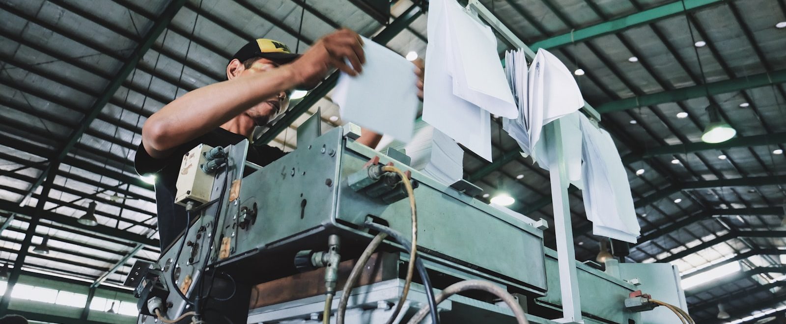 Operario revisando documentación de control de calidad junto a una máquina