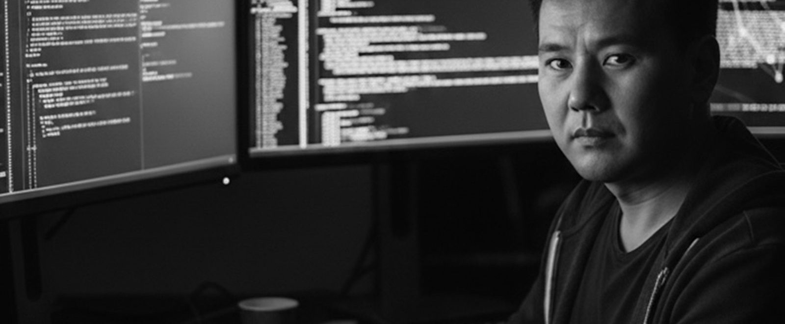 Persona trabajando frente a varios monitores de sistemas
