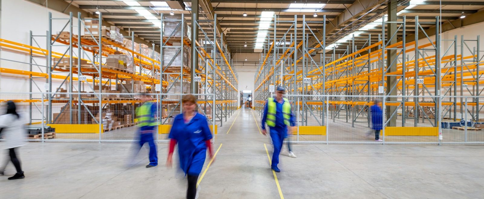 Trabajadores caminando por el pasillo de un almacén