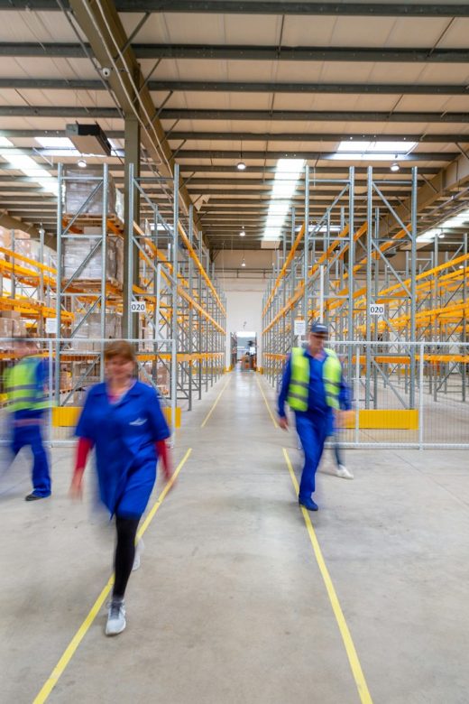 Trabajadores caminando por el pasillo de un almacén